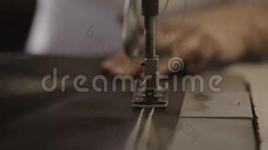 工人在工厂用缝纫机在皮革材料上制造接缝。 关门